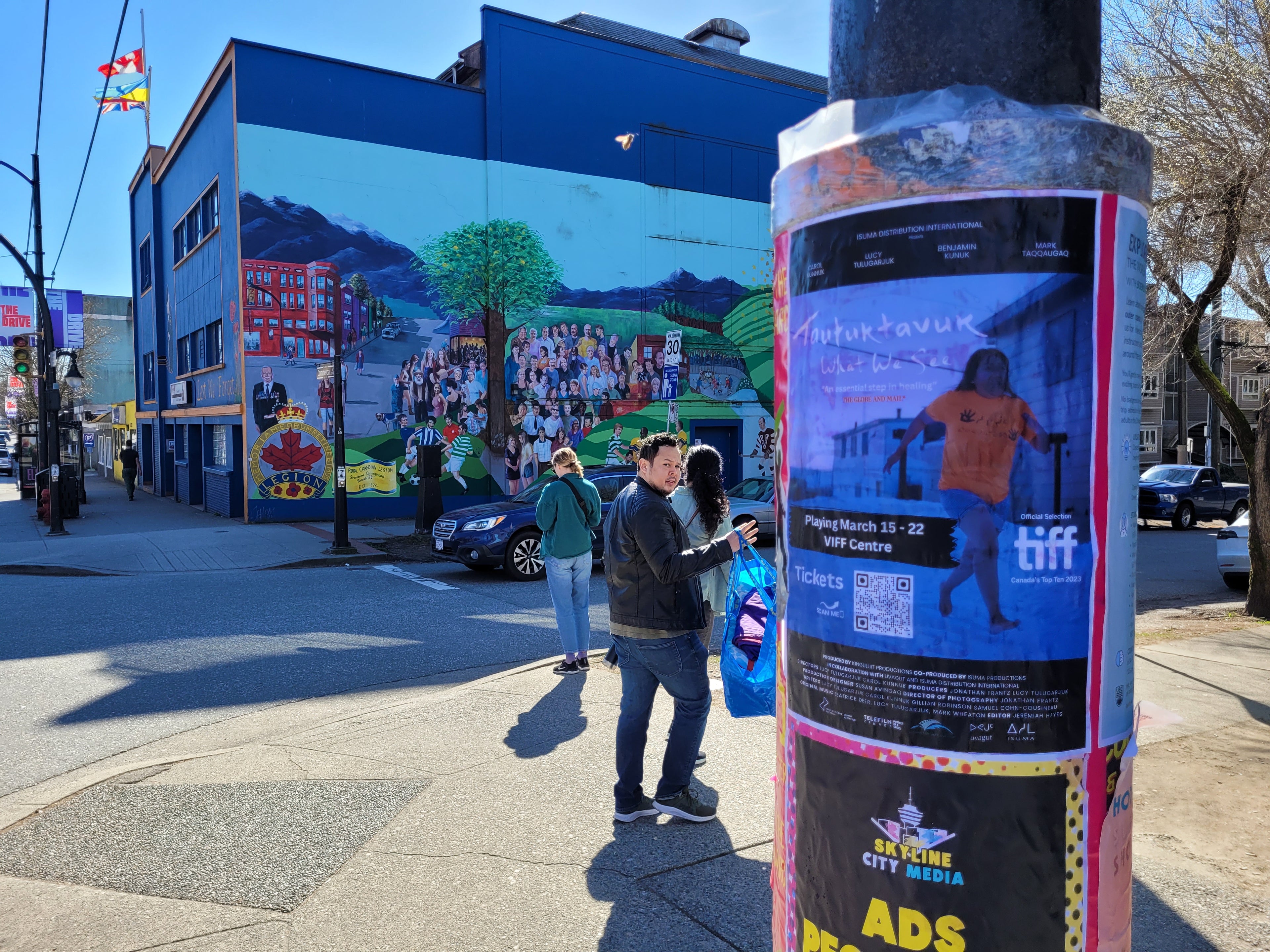 Posters on a pole on a busy street corner in Vancouver by Skyline City Media