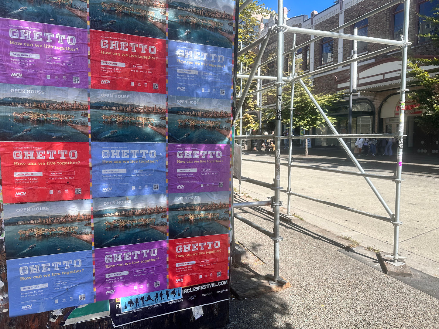 Large format postering collage on a street next to some scaffolding - posters installed by Skyline City Media