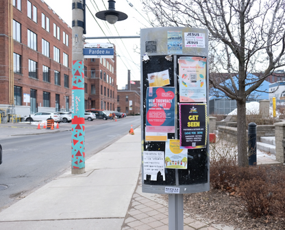 Posters on a city postering board on the street of Downtown Toronto - postering campaign by Skyline City Media